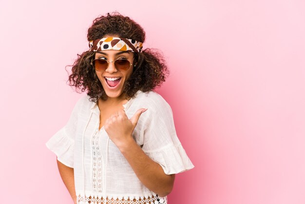 Jeune femme afro-américaine hipster isolée sur rose