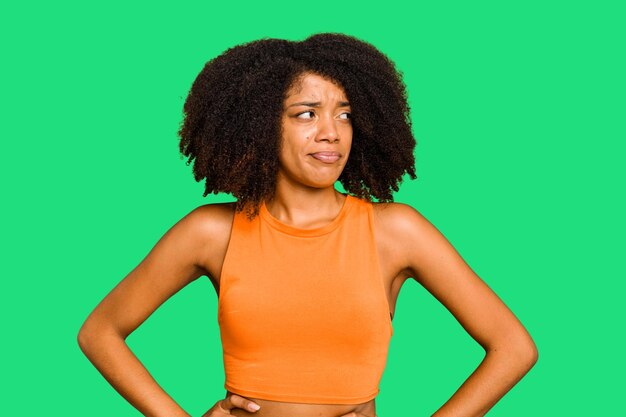 Photo une jeune femme afro-américaine isolée, confuse, douteuse et incertaine.