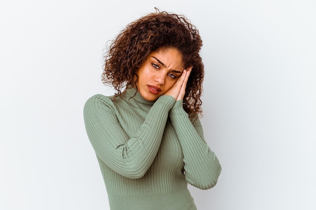 Jeune femme afro-américaine isolée sur fond blanc bâillement montrant un geste fatigué couvrant la bouche avec la main.