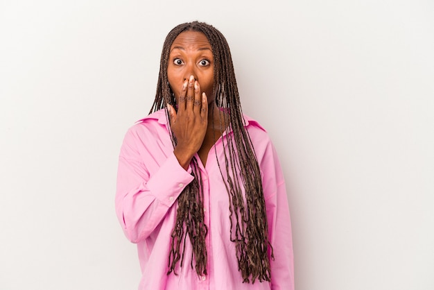 Jeune femme afro-américaine isolée sur fond blanc choquée, se couvrant la bouche avec les mains, impatiente de découvrir quelque chose de nouveau.