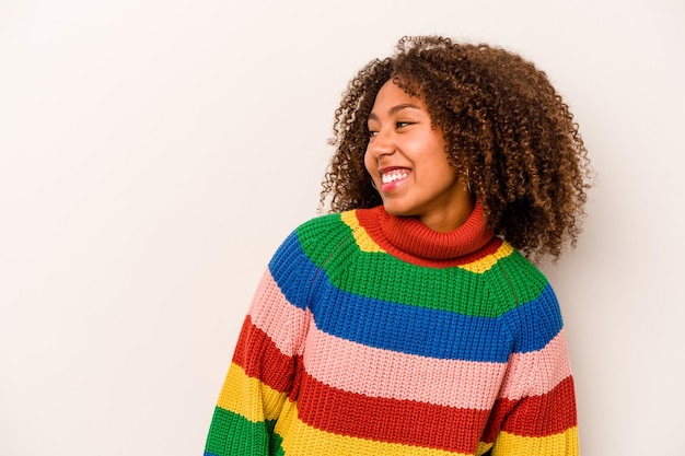 Jeune femme afro-américaine isolée sur fond blanc détendue et heureuse cou riant étiré montrant les dents