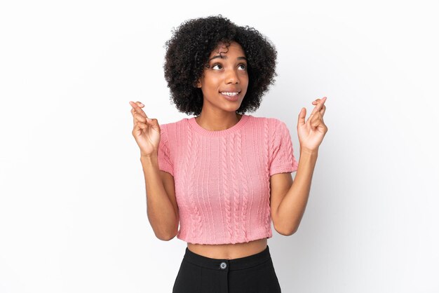 Jeune femme afro-américaine isolée sur fond blanc avec les doigts croisés et souhaitant le meilleur