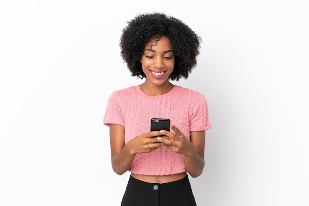 Jeune femme afro-américaine isolée sur fond blanc envoyant un message avec le mobile