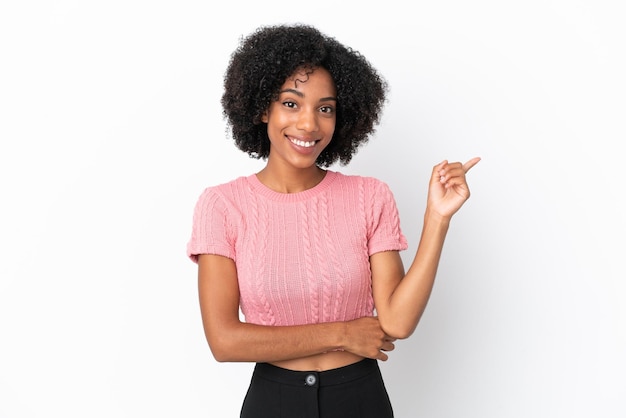 Jeune femme afro-américaine isolée sur fond blanc heureuse et pointant vers le haut