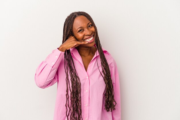 Jeune femme afro-américaine isolée sur fond blanc montrant un geste d'appel de téléphone portable avec les doigts.