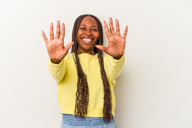 Jeune femme afro-américaine isolée sur fond blanc montrant le numéro dix avec les mains.