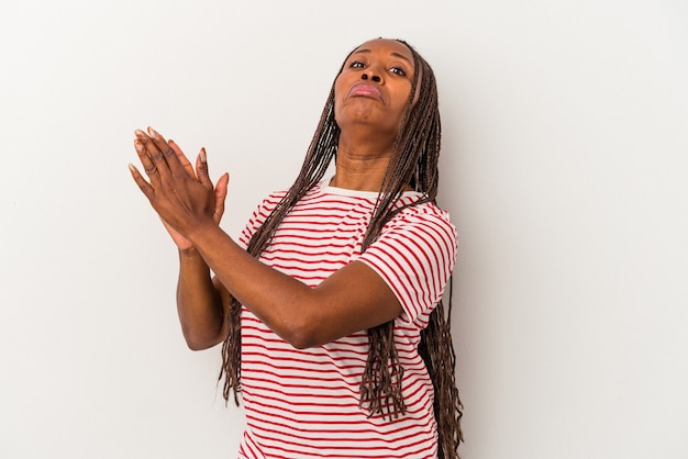 Jeune femme afro-américaine isolée sur fond blanc se sentant énergique et confortable, se frottant les mains confiantes.