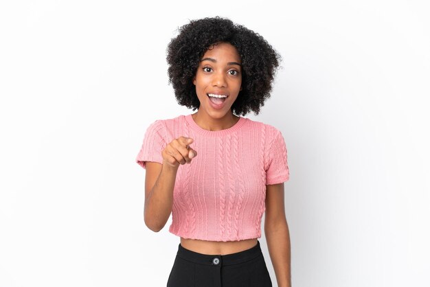 Jeune femme afro-américaine isolée sur fond blanc surpris et pointant vers l'avant