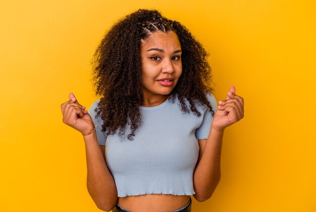 Jeune femme afro-américaine isolée sur fond jaune montrant qu'elle n'a pas d'argent.