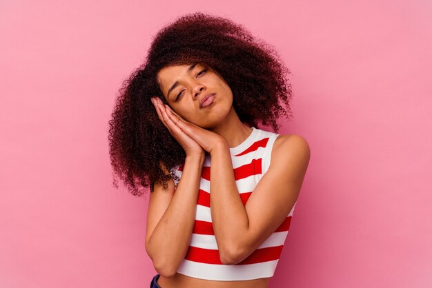 Jeune femme afro-américaine isolée sur fond rose bâillement montrant un geste fatigué couvrant la bouche avec la main.