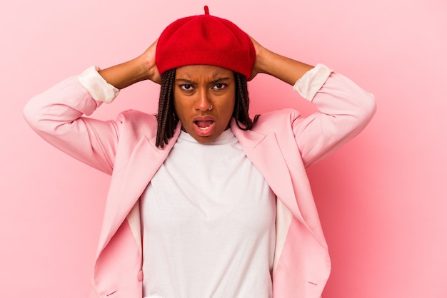 Jeune femme afro-américaine isolée sur fond rose criant, très excitée, passionnée, satisfaite de quelque chose.