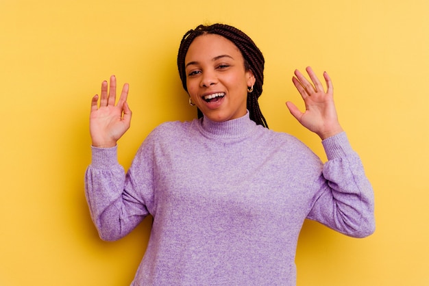 Jeune femme afro-américaine isolée sur jaune joyeux rire beaucoup. Concept de bonheur.