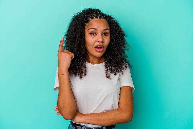 Jeune femme afro-américaine isolée sur un mur bleu ayant une bonne idée