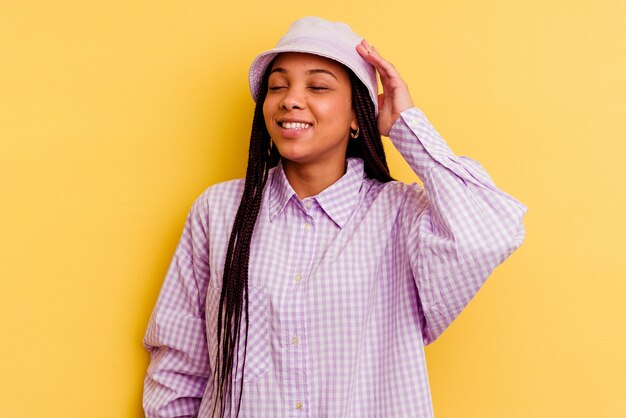 Jeune femme afro-américaine isolée sur le mur jaune joyeux rire beaucoup. Concept de bonheur.
