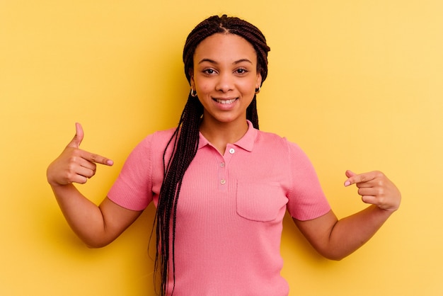 Jeune femme afro-américaine isolée sur les points jaunes vers le bas avec les doigts, sentiment positif.