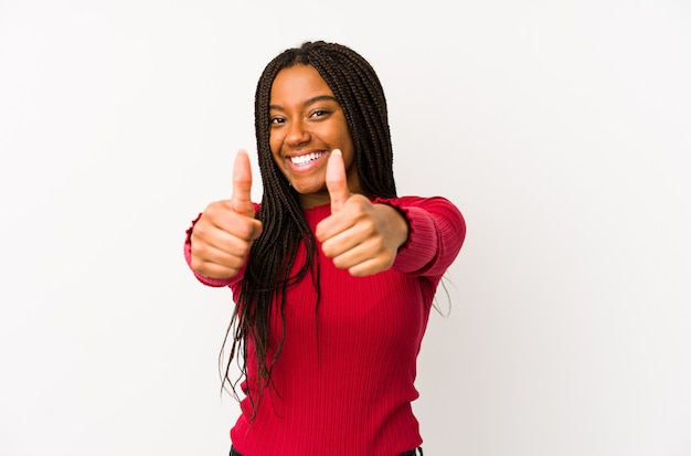 Jeune femme afro-américaine isolée avec les pouces vers le haut, acclamations sur quelque chose, le soutien et le concept de respect.