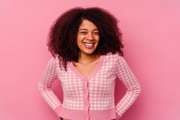 Jeune femme afro-américaine isolée sur rose heureux, souriant et joyeux.