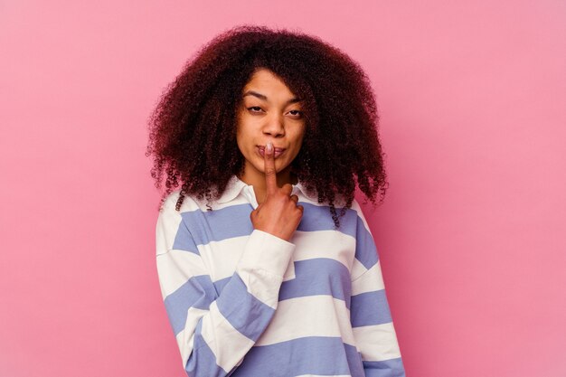 Jeune femme afro-américaine isolée sur rose pensant et levant, réfléchissant, contemplant, ayant un fantasme.