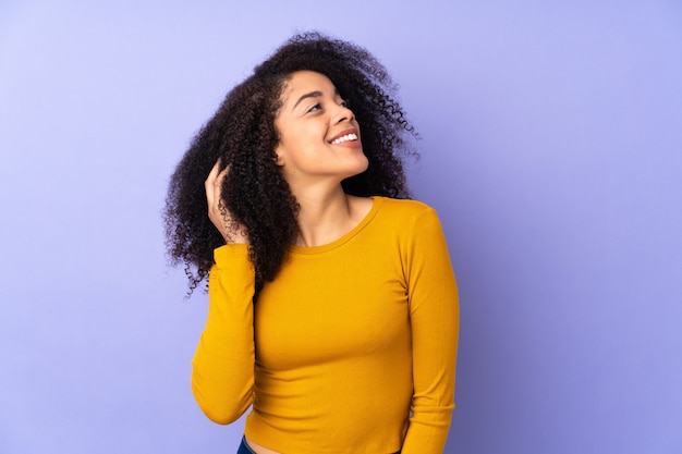 Jeune femme afro-américaine isolée sur violet pensant une idée