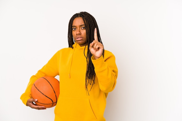 Jeune femme afro-américaine jouant au basket-ball isolé montrant le numéro un avec le doigt.