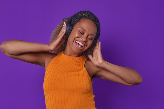 Photo jeune femme afro-américaine joy chante en écoutant de la musique sur des écouteurs