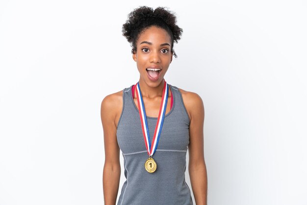 Jeune femme afro-américaine avec des médailles isolées sur fond blanc avec une expression faciale surprise