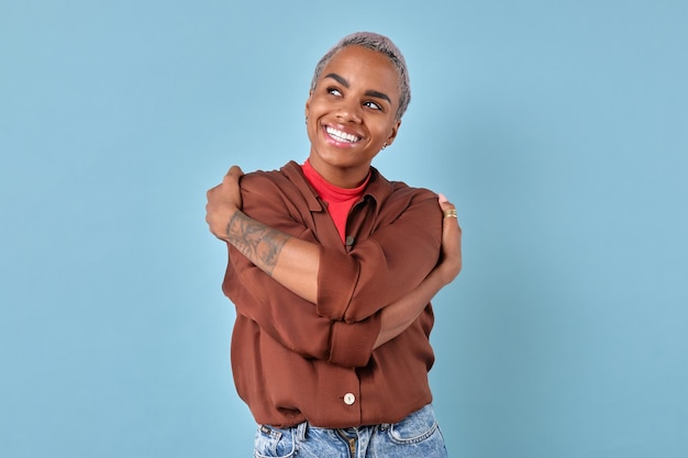 Une jeune femme afro-américaine mignonne, Zoomer, s'embrassant, se tient dans le studio.