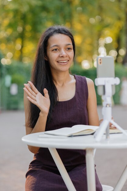 Jeune femme afro-américaine millénaire regardant un webinaire ou une diffusion en direct depuis son smartphone