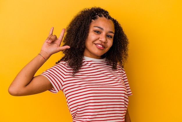 Jeune femme afro-américaine montrant un geste de cornes comme un concept de révolution.