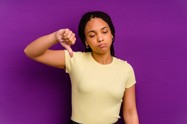 Jeune femme afro-américaine montrant un geste de dégoût, les pouces vers le bas. Concept de désaccord.