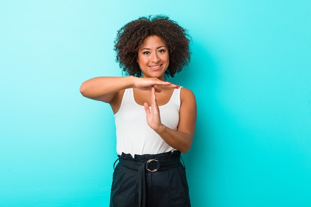 Jeune femme afro-américaine montrant un geste de temporisation.