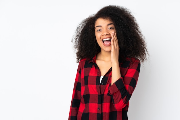 Jeune femme afro-américaine sur mur criant avec la bouche grande ouverte