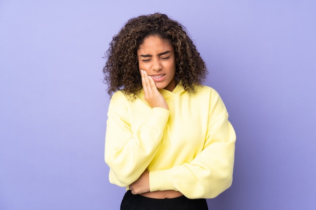 Jeune femme afro-américaine sur mur avec mal aux dents