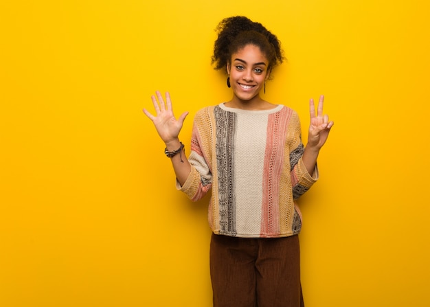 Jeune femme afro-américaine noire aux yeux bleus montrant le numéro sept