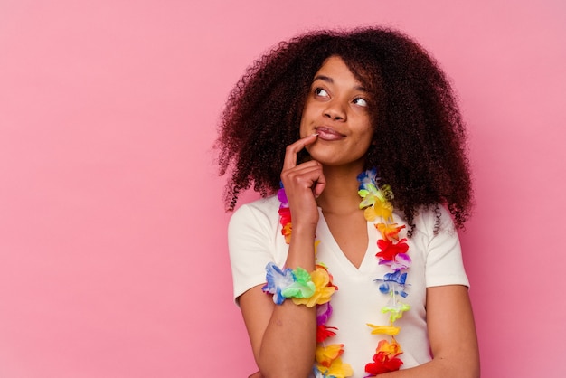 Jeune femme afro-américaine portant un truc hawaïen détendu penser à quelque chose en regardant un espace de copie.