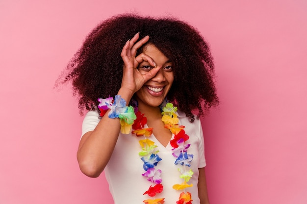 Jeune Femme Afro-américaine Portant Un Truc Hawaïen Excité En Gardant Un Geste Correct Sur Les Yeux.