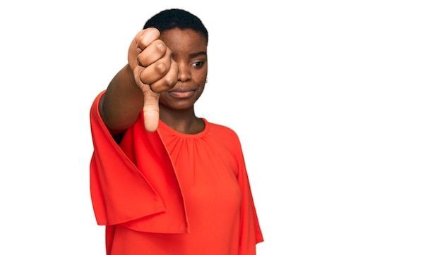 Jeune femme afro-américaine portant des vêtements décontractés à l'air malheureux et en colère montrant le rejet et négatif avec les pouces vers le bas geste mauvaise expression