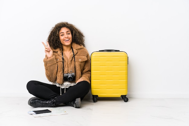 Jeune Femme Afro-américaine Prête Pour Un Voyage Joyeux Et Insouciant Montrant Un Symbole De Paix Avec Les Doigts.