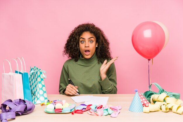 Jeune femme afro-américaine prévoit un anniversaire surpris et choqué.