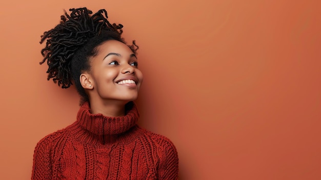 Une jeune femme afro-américaine réfléchie portant un pull à col rouge détourne le regard et sourit.