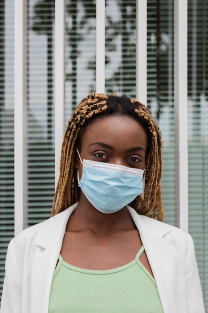 Jeune femme afro-américaine regardant la caméra portant un masque de protection Soins de santé verticaux