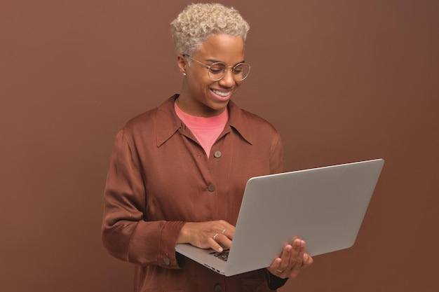 Jeune femme afro-américaine souriante utilisant un ordinateur portable pour des rencontres en ligne