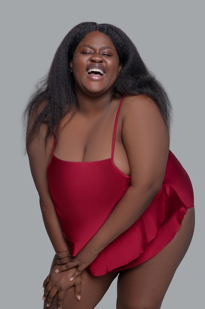 Jeune femme afro-américaine en sous-vêtements rouges souriant et à la recherche attrayante