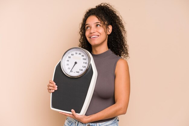 Jeune femme afro-américaine tenant une balance isolée