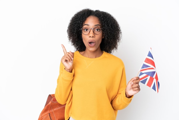 Jeune femme afro-américaine tenant un drapeau du Royaume-Uni isolé sur fond blanc dans l'intention de réaliser la solution tout en levant un doigt vers le haut