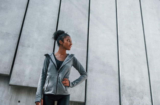 Une jeune femme afro-américaine en vêtements sportifs s'entraîne à l'extérieur pendant la journée