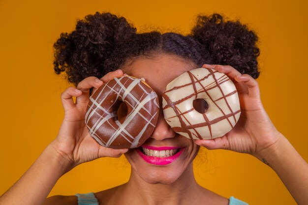 Jeune femme afro avec des beignets