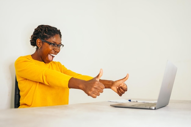 Jeune femme afro célébrant en télétravail