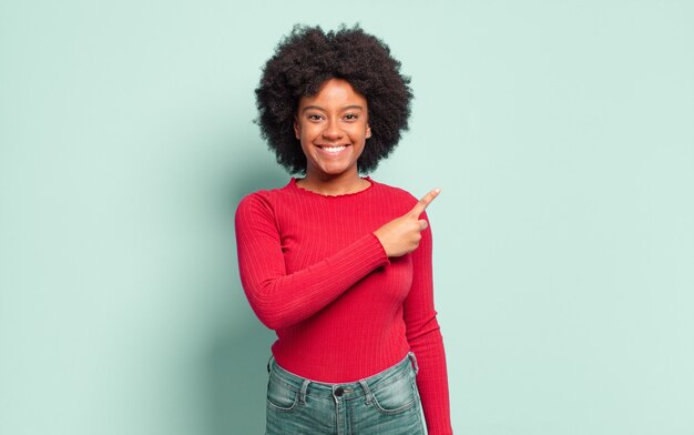 jeune femme afro contre un mur isolé