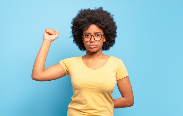 jeune femme afro contre un mur isolé